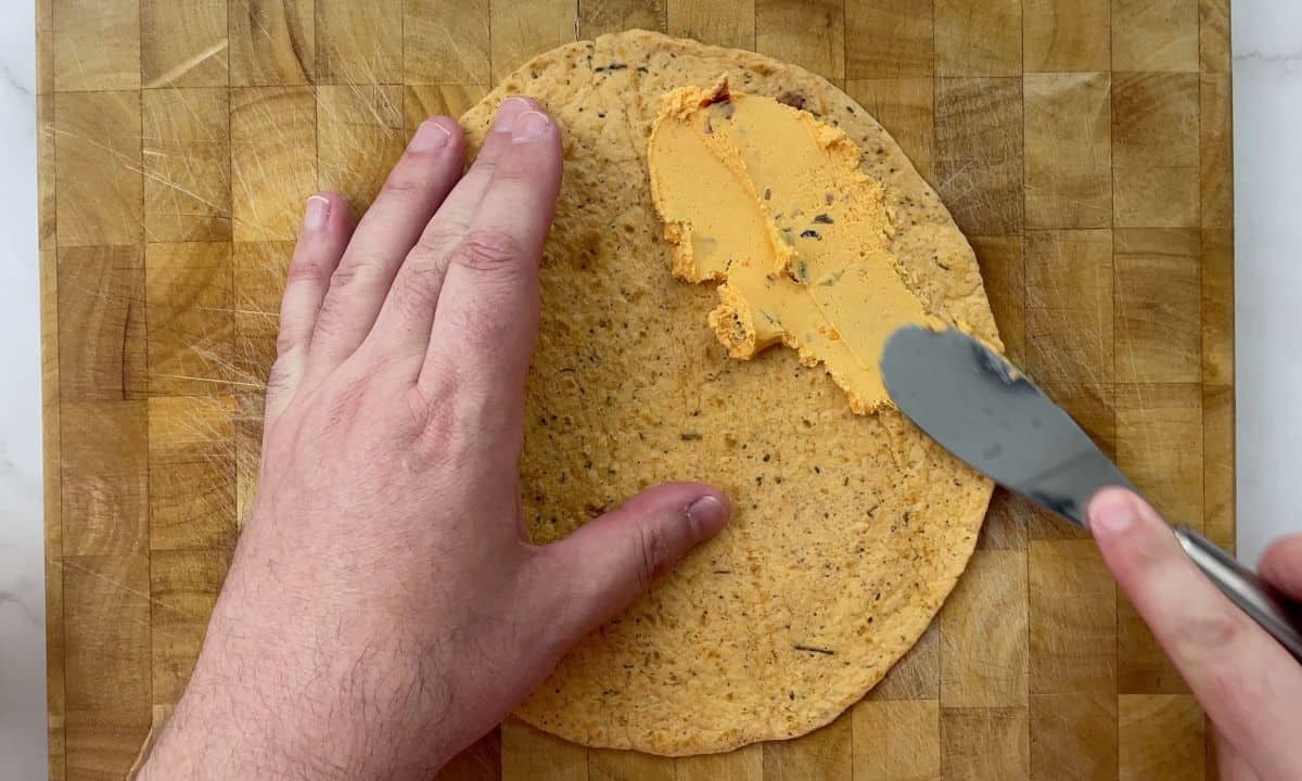 spreading the jalapeno pub cheese on the tortilla.