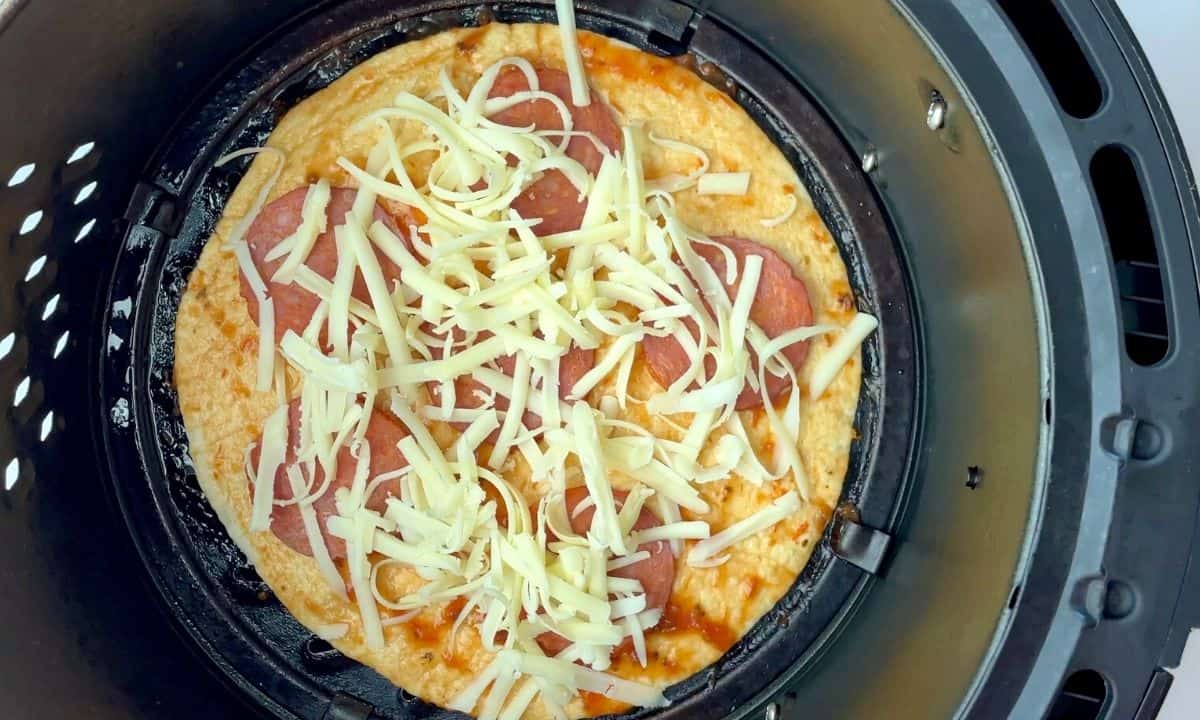 uncooked tortilla pizza in the air fryer basket.