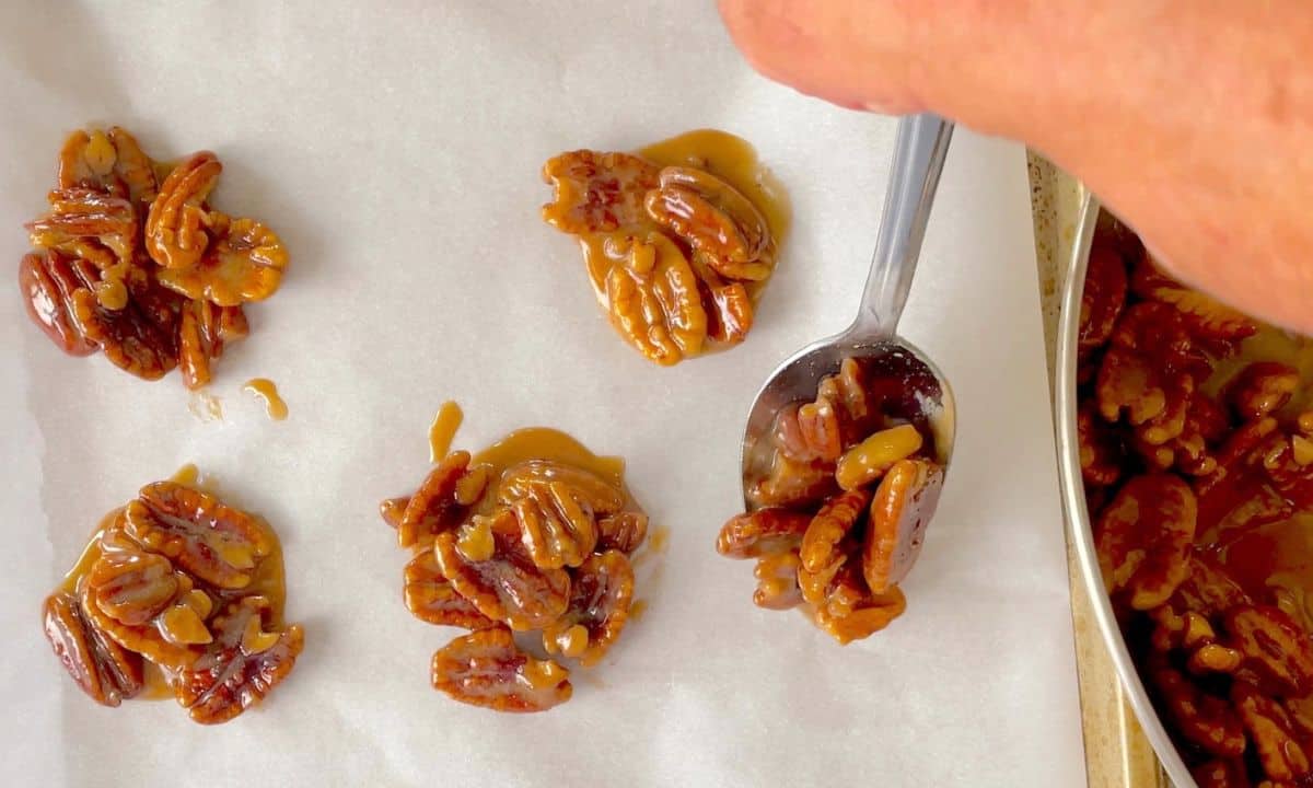 spooning the pecan pralines onto the parchment lined baking sheet.