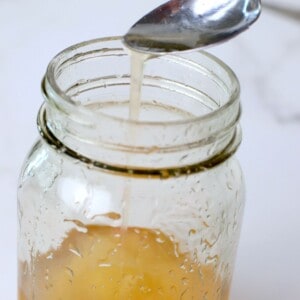 a spoon dripping keto corn syrup into a jar.