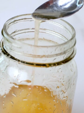 a spoon dripping keto corn syrup into a jar.