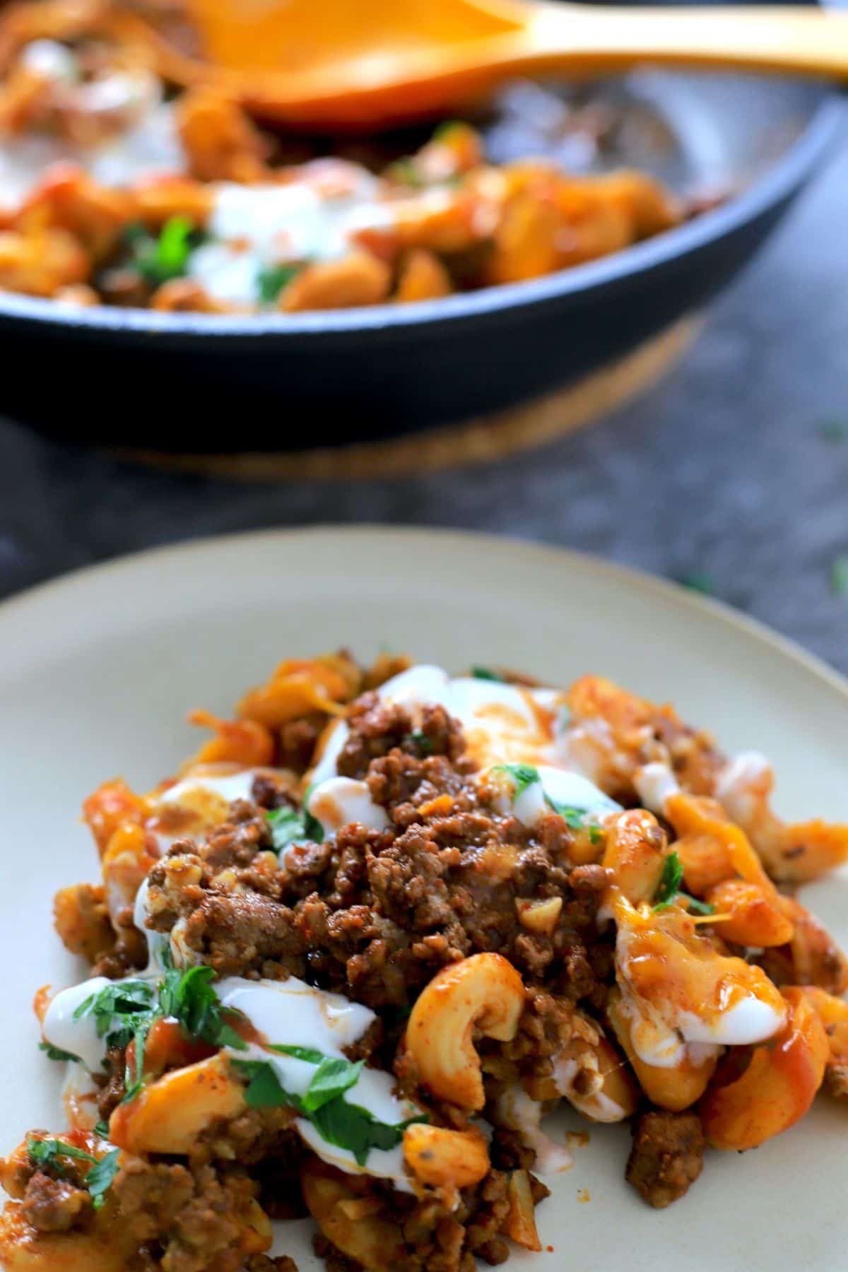 keto taco pasta on a plate next to a skillet of the same.