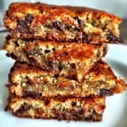 Four chocolate chip almond flour blondie squares stacked on top of each other.