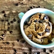 bowl of ice cream coffee with coffee beans sprinkled on the table.