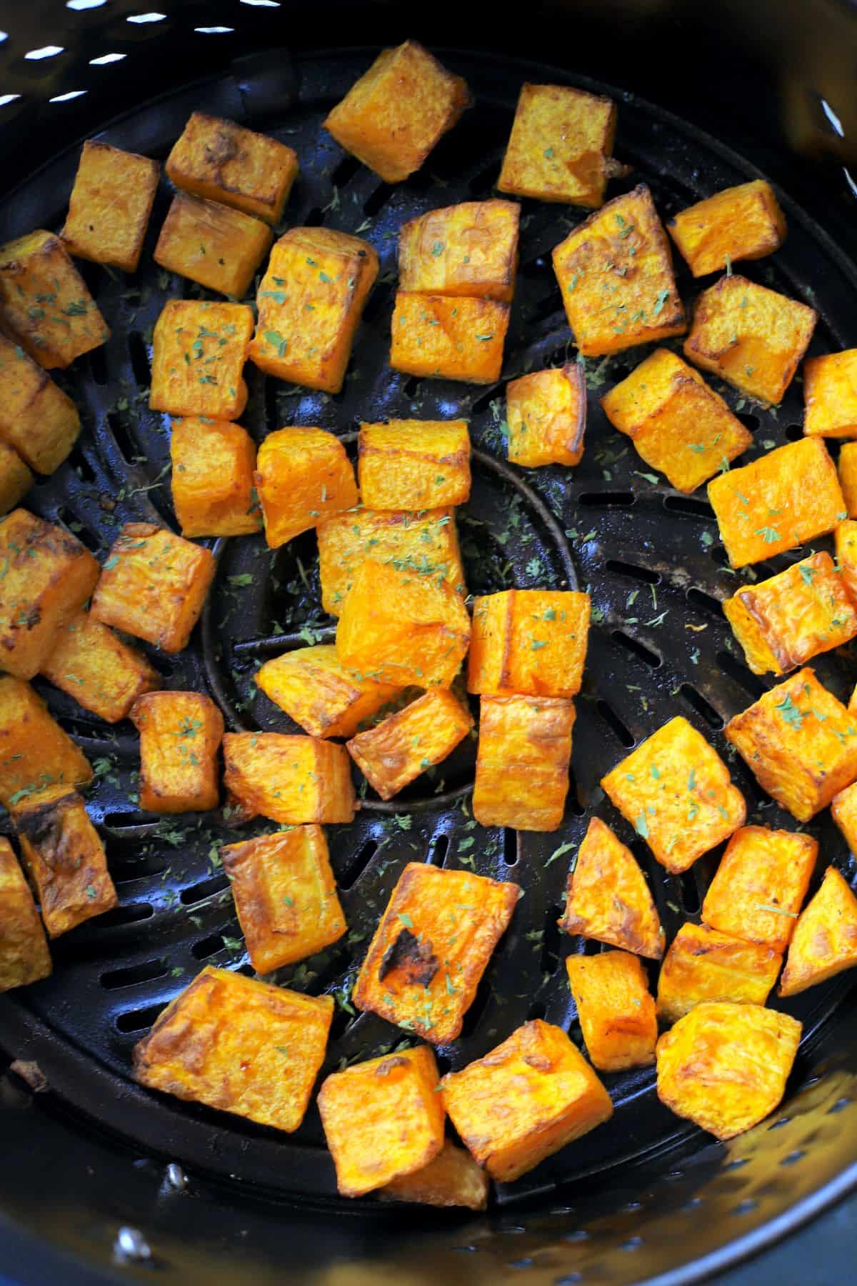 air fried butternut squash in the air fryer basked.