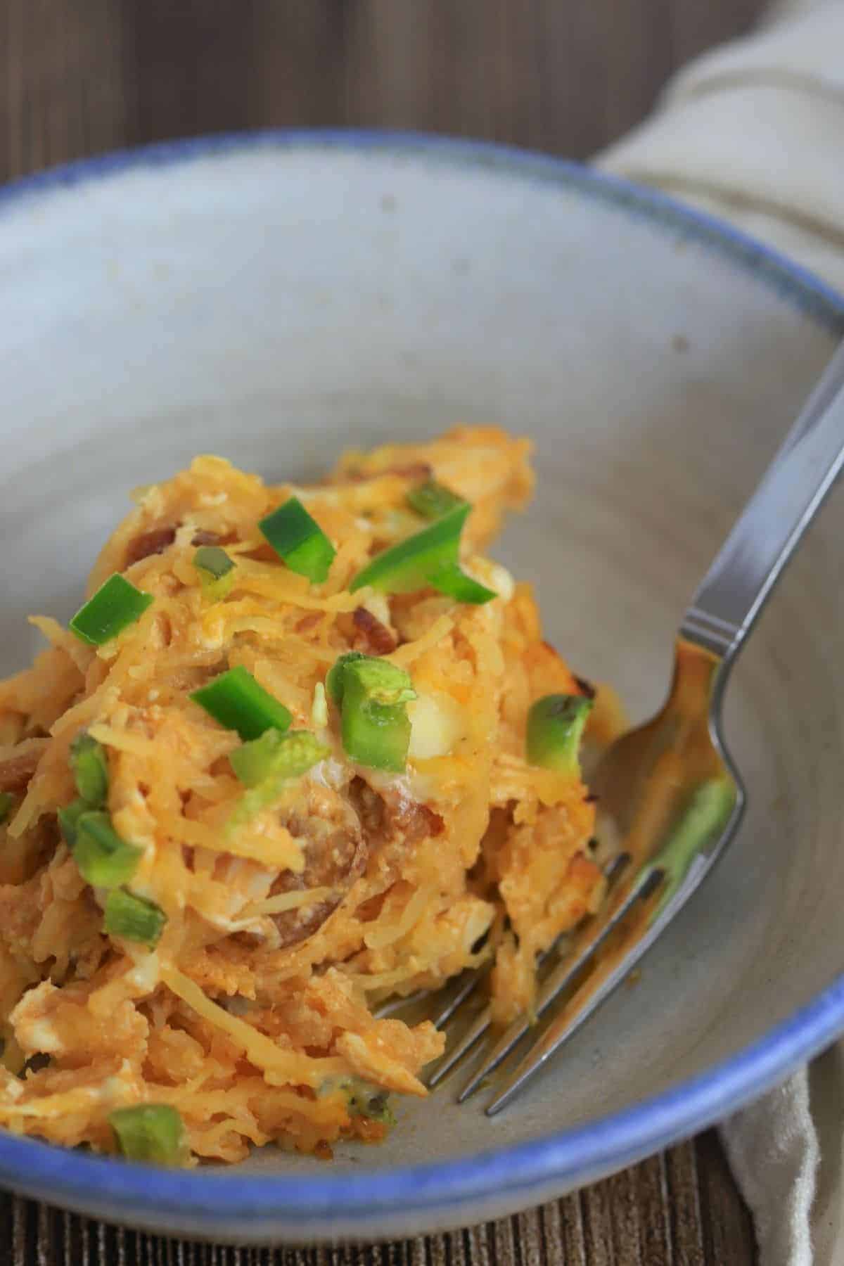 Bowl with buffalo chicken spaghetti squash and a spoon.