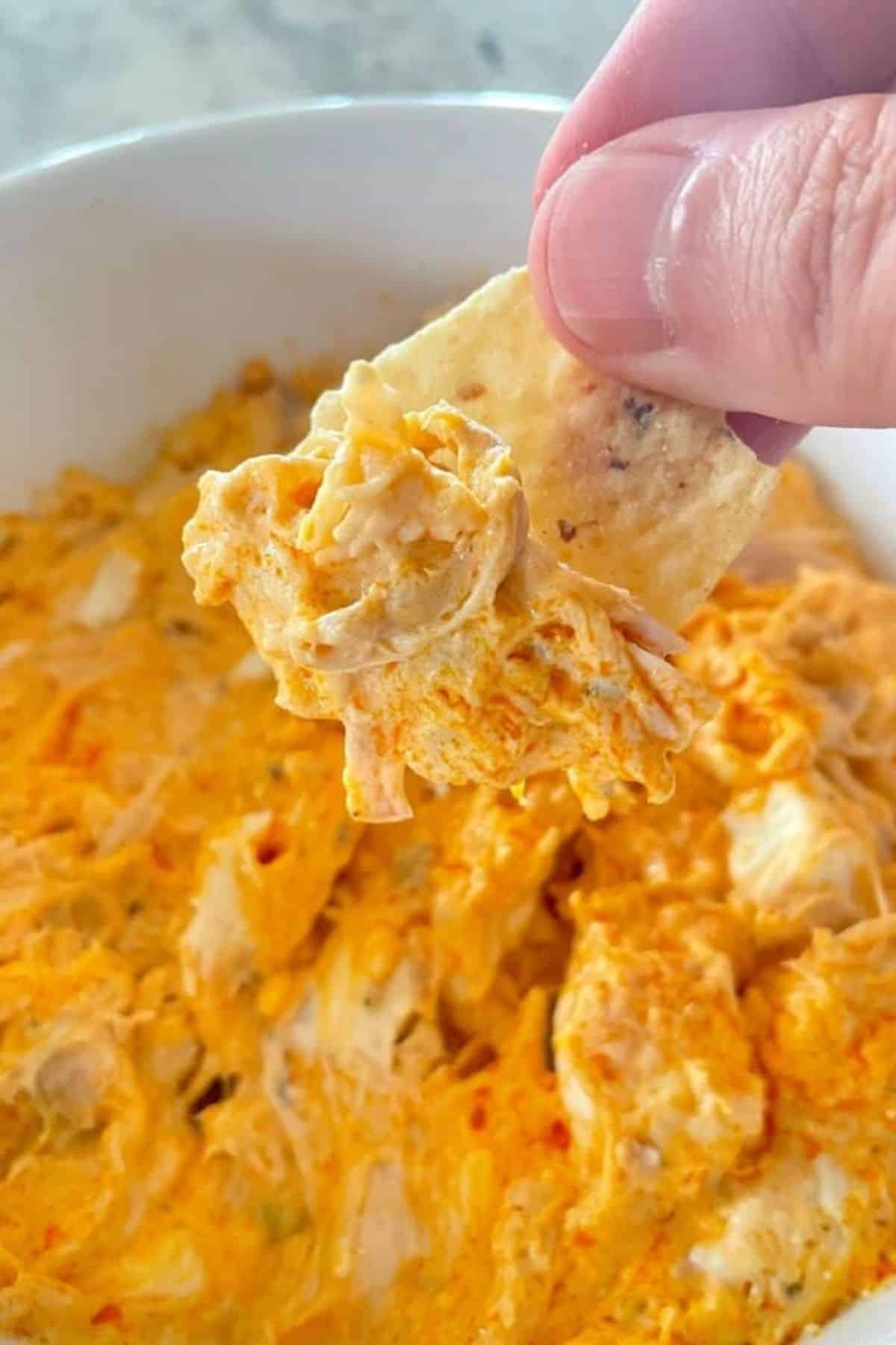 dipping a tortilla chip into the spaghetti squash casserole.