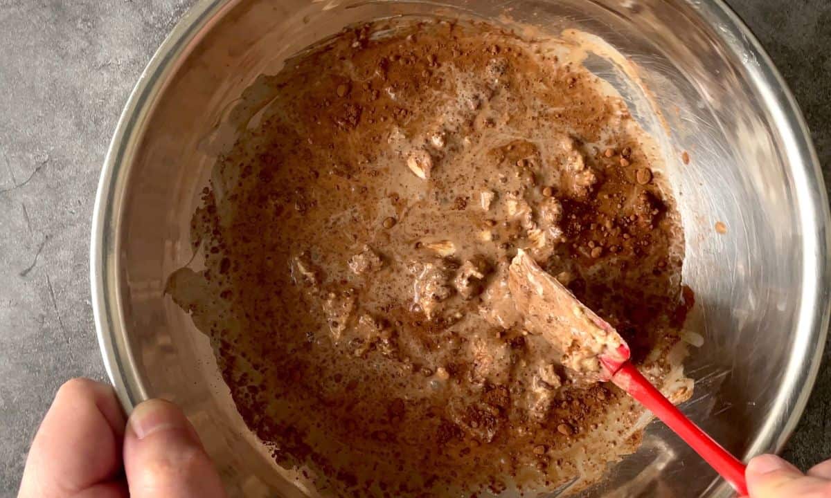 ingredients in a bowl with a red rubber spatula.