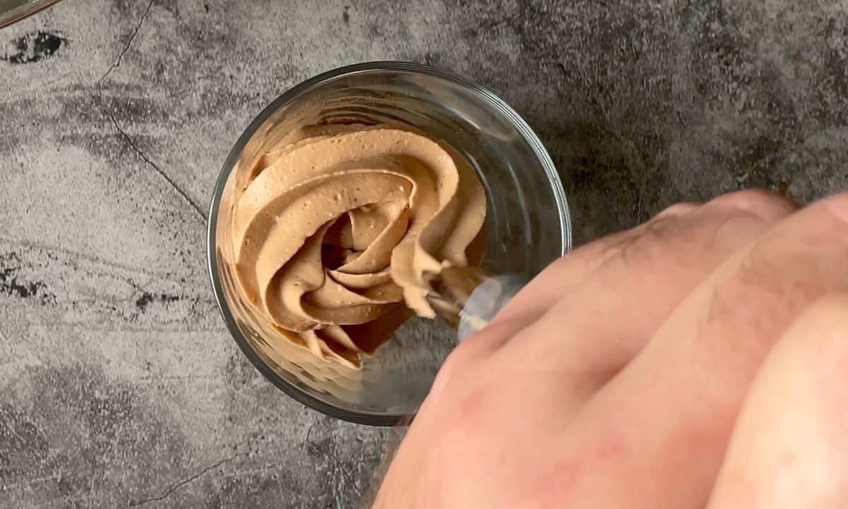 piping the mousse into a tumbler glass.