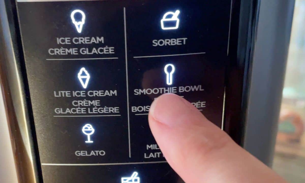 finger pointing to the smoothie bowl button on the ninja creami machine.