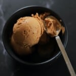 black bowl with tiramisu ice cream and a silver spoon.