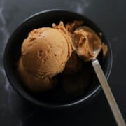 black bowl with tiramisu ice cream and a silver spoon.