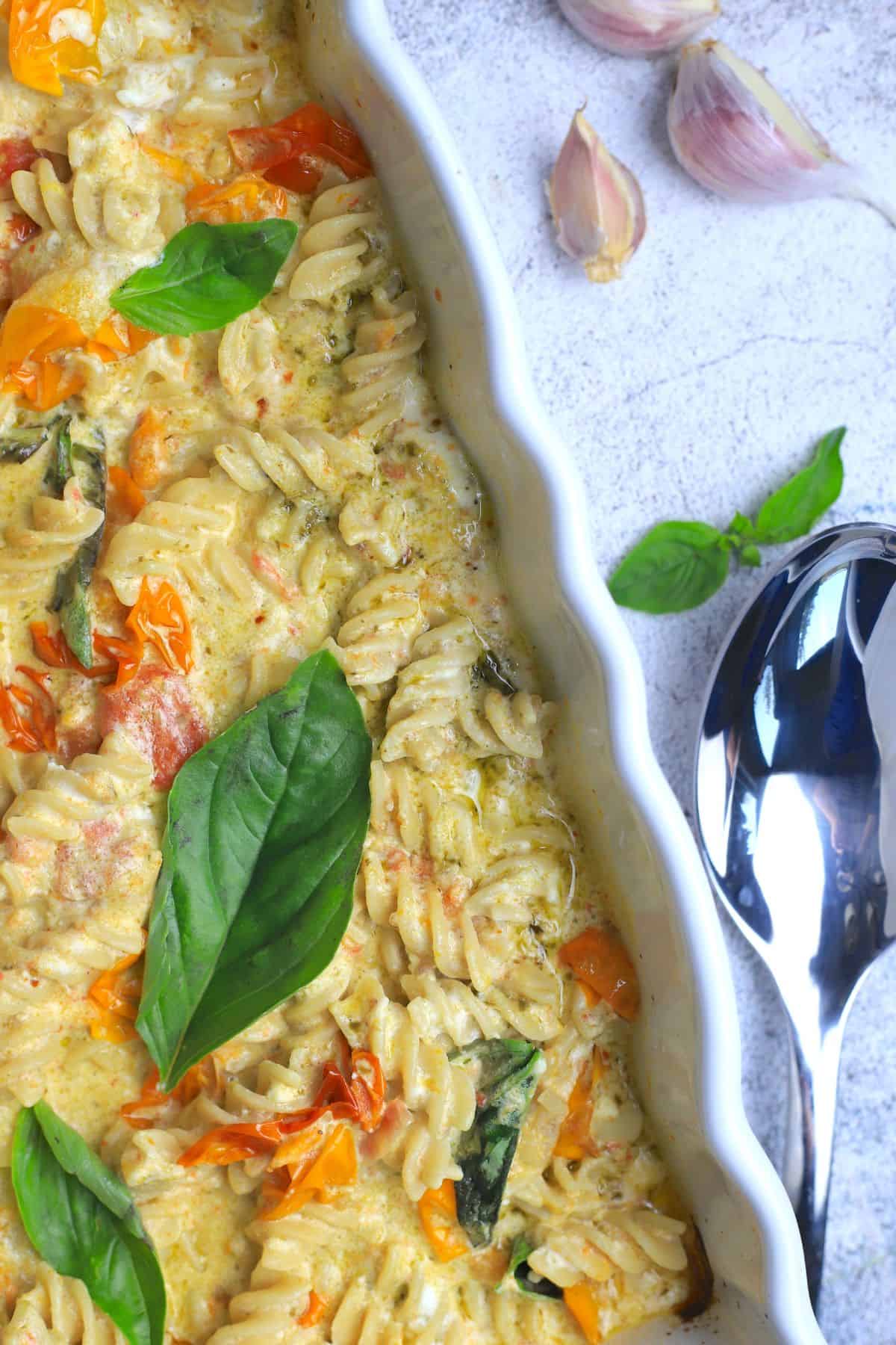 baked goat cheese pasta in a white casserole dish.