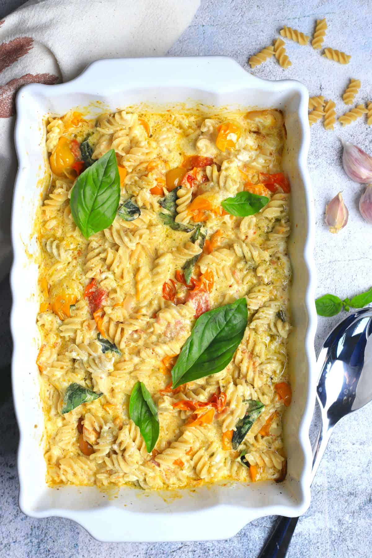 baked goat cheese pasta in a white casserole dish.