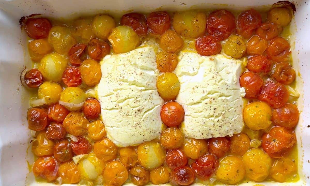 baked tomatoes and goat cheese in a white casserole dish.