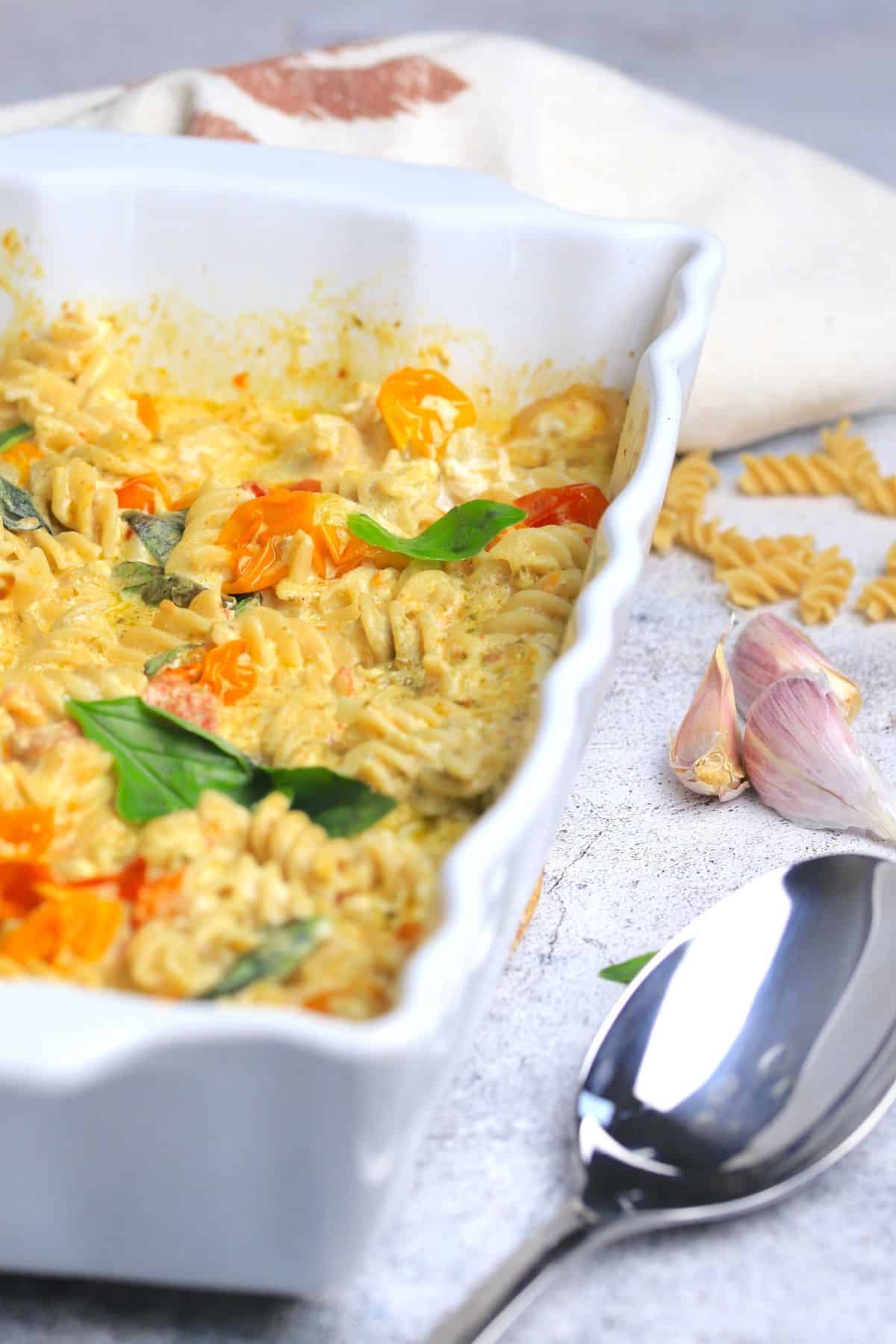 baked goat cheese pasta in a white casserole dish.