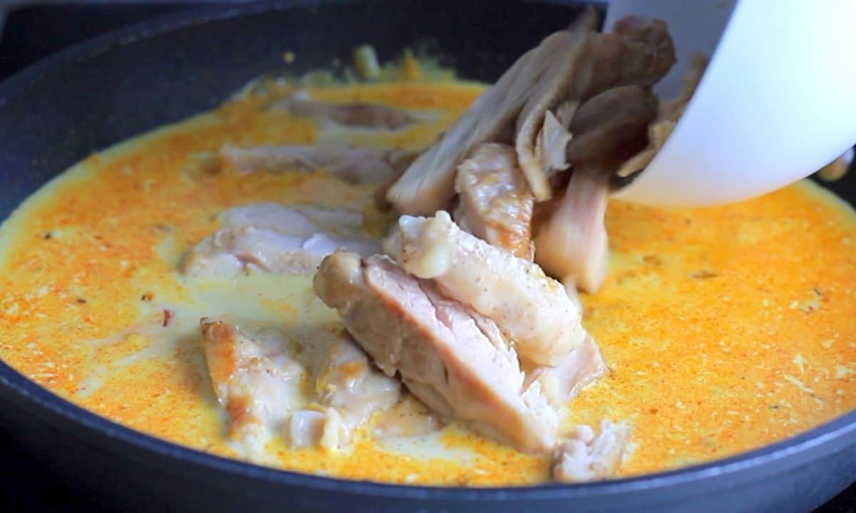 adding the chicken into the sauce in the skillet pan.