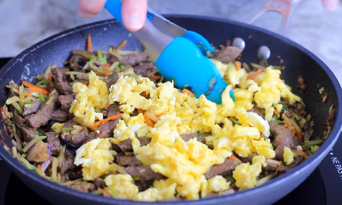 combining egg in the pan with the moo shu beef.