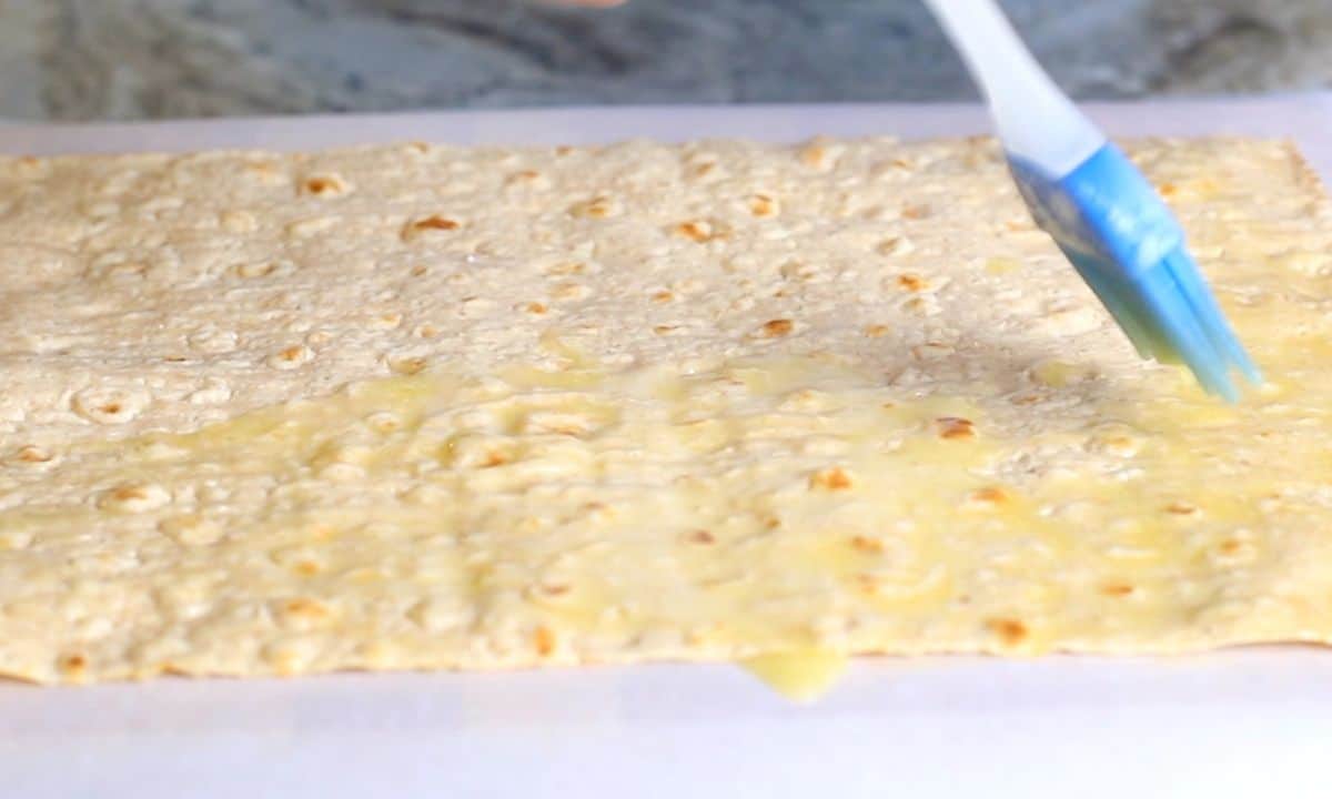 brushing butter on the lavash bread.