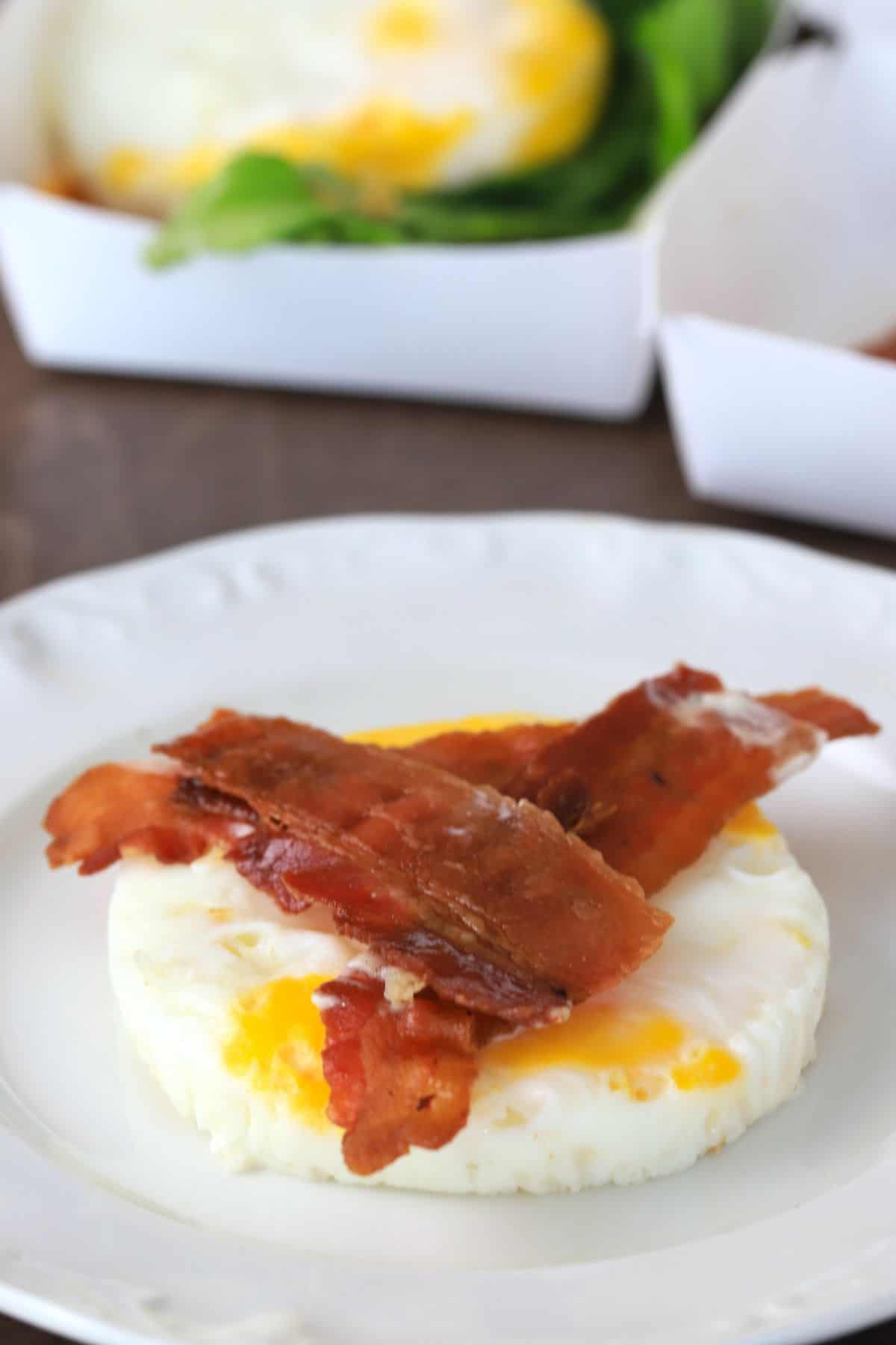 a round egg with strips of bacon on top.