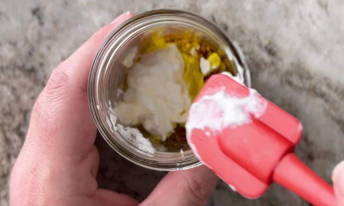 jar with salad dressing and a red rubber spatula.