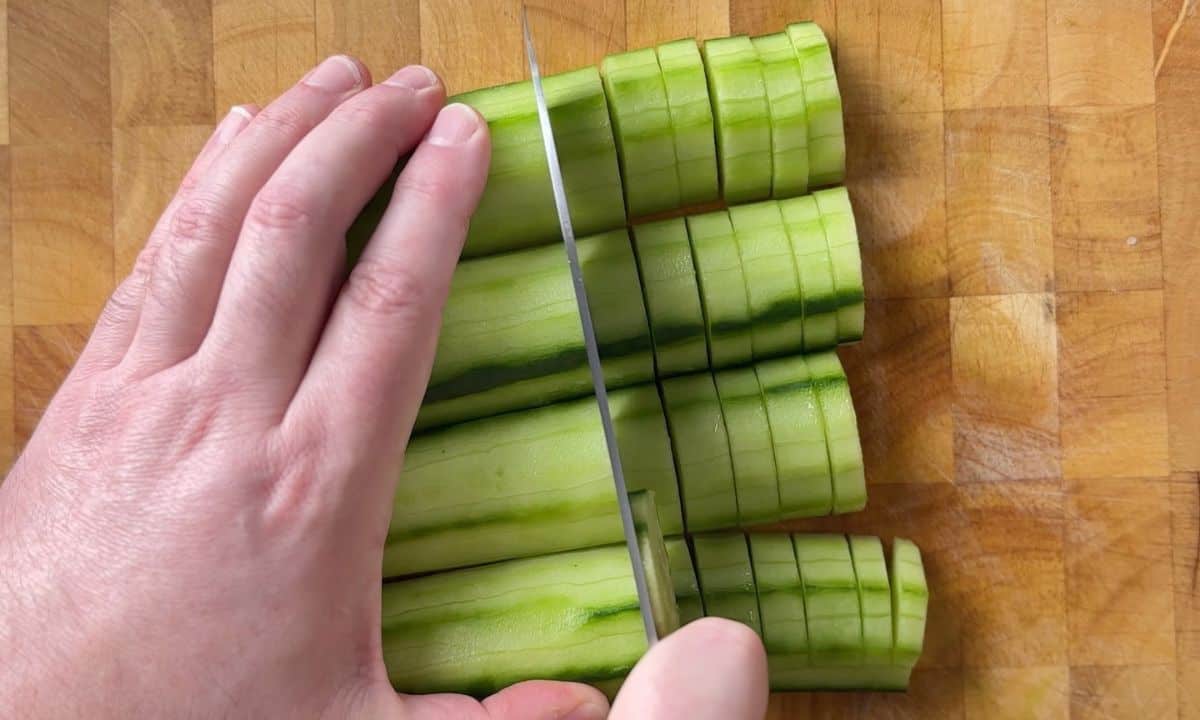 cutting cucumbers on a cutting board.