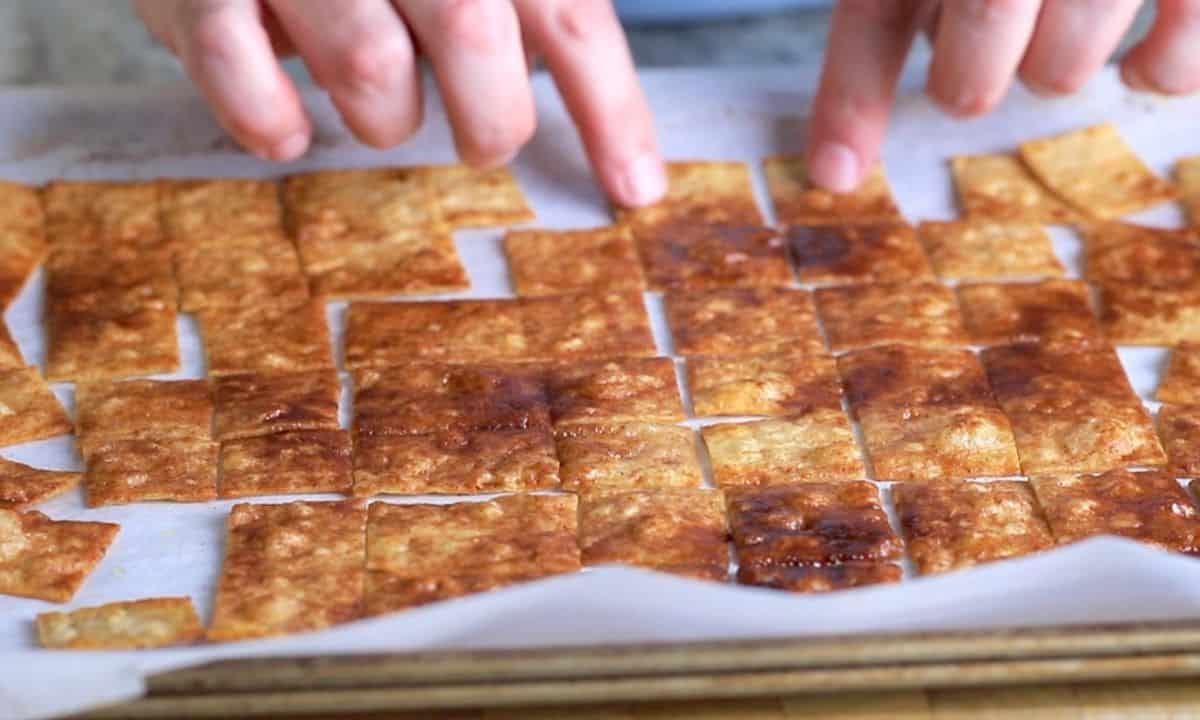spreading crackers apart on a parchment lined baking sheet.