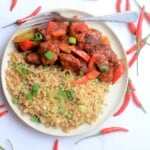 angry chicken on a plate with cauliflower rice and chili peppers on the side.