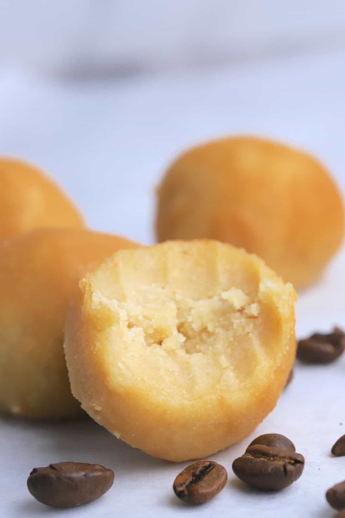 Maple protein coffee bites next to some coffee beans.