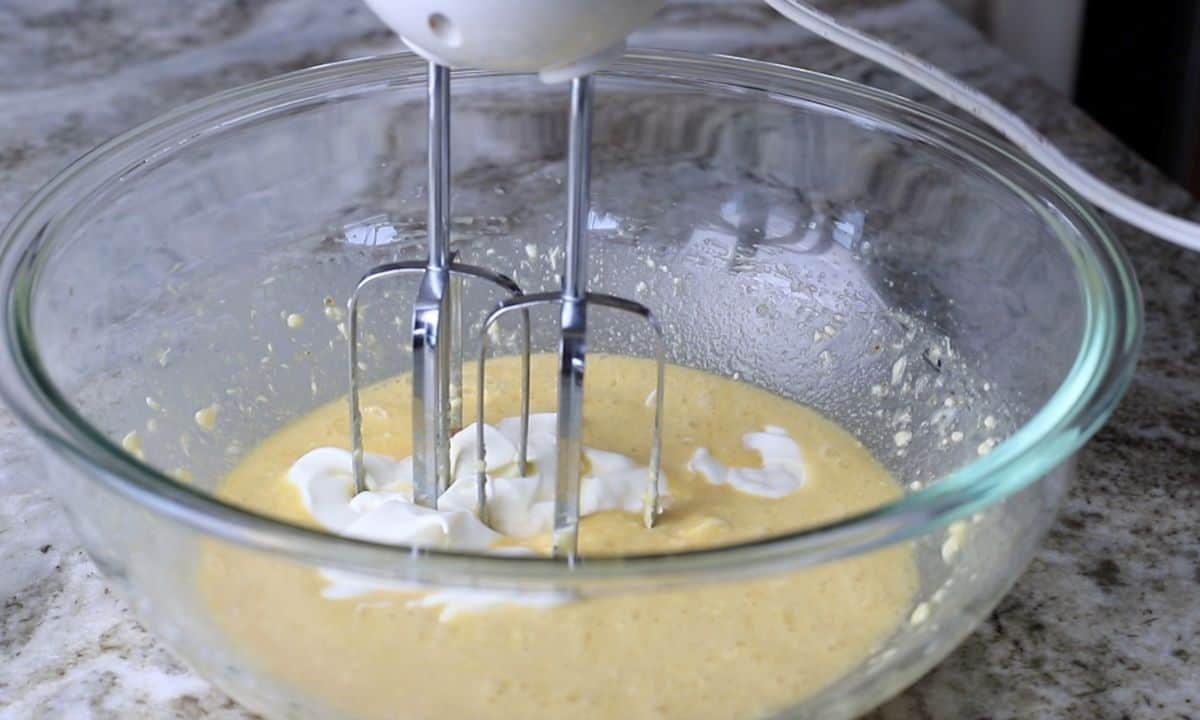 hand mixer in a bowl with wet ingredients.