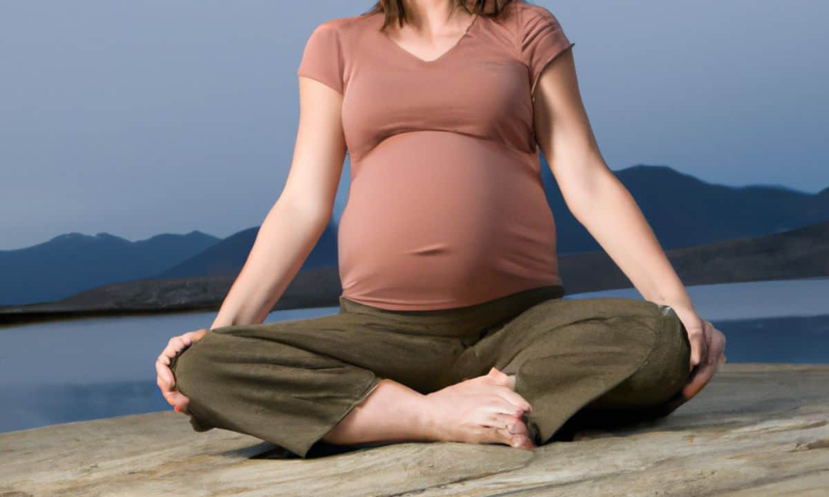 pregnant female doing yoga with mountains behind her.