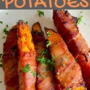 5 air fried low carb bacon wrapped sweet potatoes on a white plate with a parsley garnish.