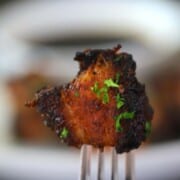 keto air fryer pork belly on a white plate with a fork and a bowl of soy sauce