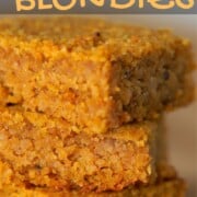3 Keto Pumpkin Spice Blondies stacked on top of each other on a cutting board.