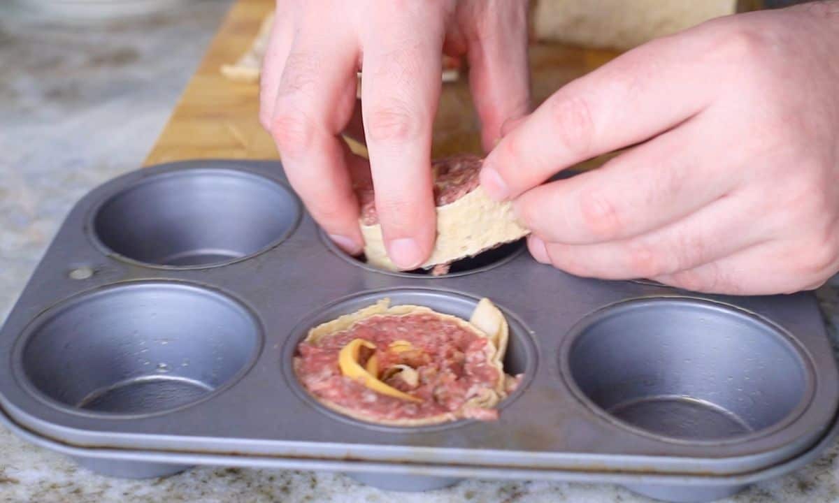 placing rolls into a muffin tin.