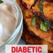 diabetic spaghetti squash fritters stacked on a white plate with a side dip.