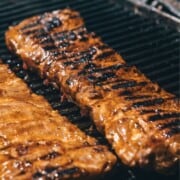 2 baby back ribs on a bbq grill.