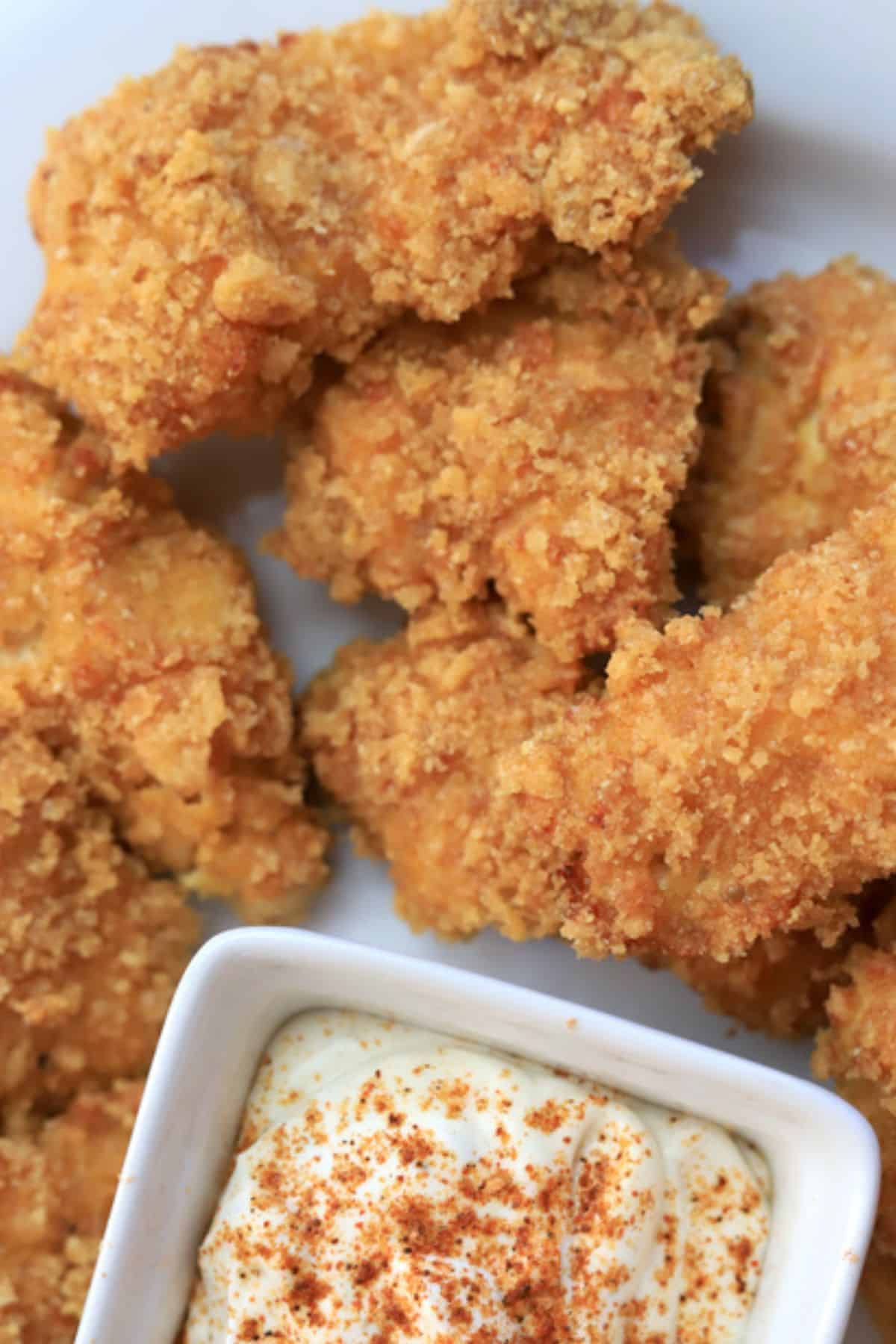 keto chicken nuggets next to a dipping sauce.