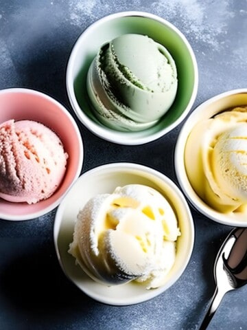 four bowl with different ice cream in each with a spoon on the side.