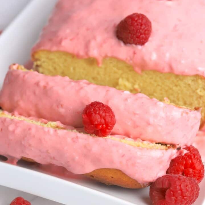 almond raspberry cake with raspberry icing cut into slices.