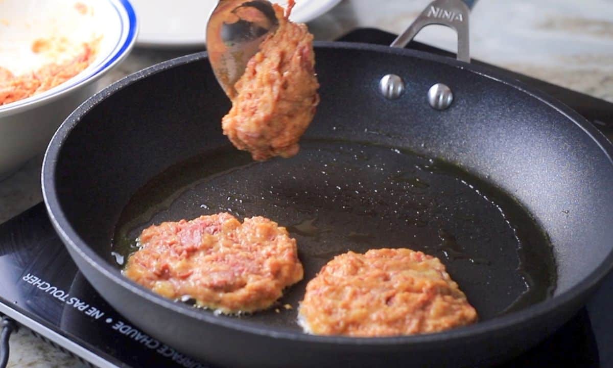 frying the corned beef fritters in a frying pan.