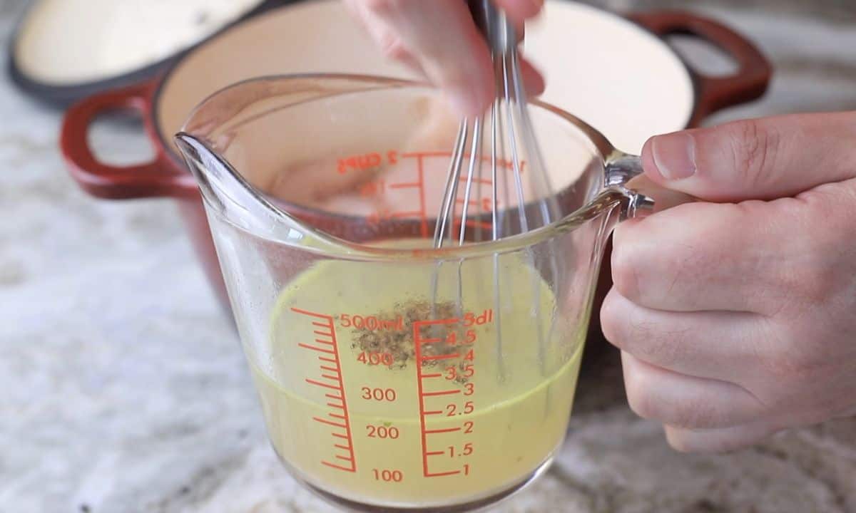 mixing the chicken broth with a whisk.