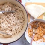 pulled chicken in the dutch oven pot next to a bowl with chicken and taco seasoning.