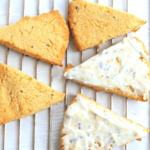 Almond flour scones on a cooling rack with a lemon rosemary frosting.