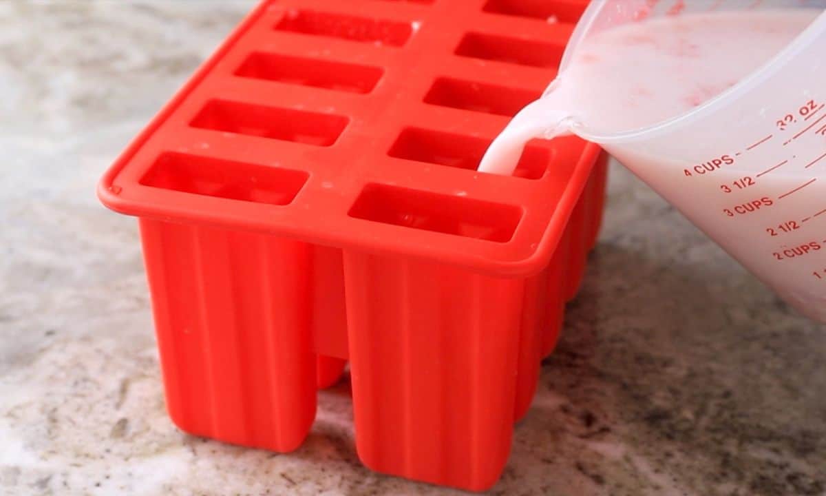 Pouring the liquid into the popsicle molds.