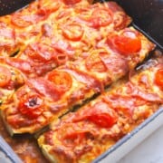 Zucchini Pizza Boats topped with cheese, cherry tomatoes and salami.