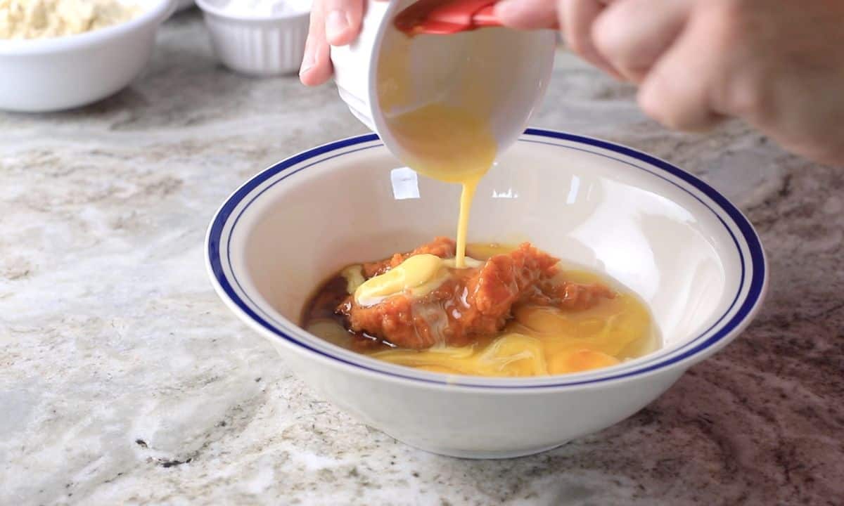 pouring melted butter into the wet mixture.