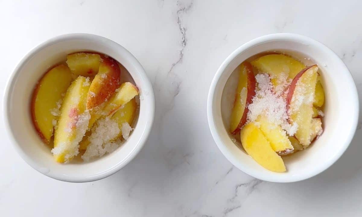 Slices of peaches in two ramekin dishes with sprinkles of granular sweetener.