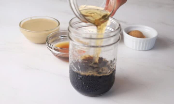 pouring ingredients into a glass jar.