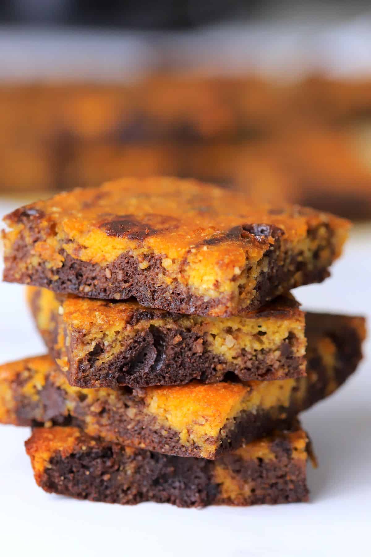 Four healthy pumpkin brownies stacked on top of each other.